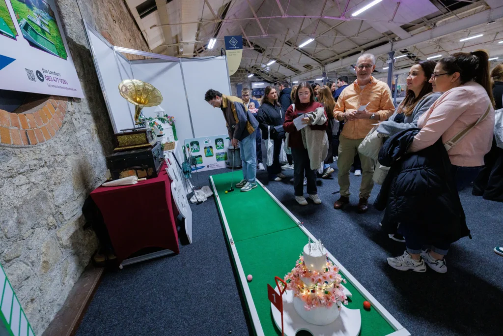 People enjoying mini-golf at a lively indoor event with engaging exhibits and displays.