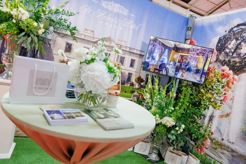 Hotel event display with floral arrangements and promotional materials at St. Helen's Hotel booth.